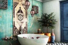 a boho bathroom with a Moroccan feel – an aqua plaster wall, a rug as an artwork and gorgeous Moroccan lanterns hanging
