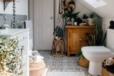 a boho bathroom with potted greenery and succulents, baskets for storage, a mosaic tile floor and some rich stained wooden items