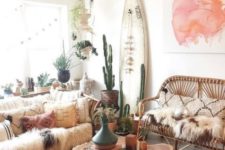 a boho chic living space with a surf board, rattan furniture, wood slice coffee table and potted greenery and cacti