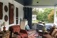 a boho meets retro porch with a dining and living room zone, decorative plates and rugs on the wall and lots of colorful ottomans