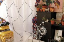 a bold boho bathroom with bright textiles – towels and a curtain, potted greenery and blooms all over