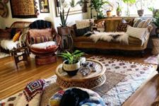 a bright boho space with colorful ottomans, pillows, a rattan chair, wicker lamps, a bold gallery wall and potted plants