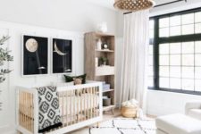 a catchy neutral nursery with touches of black for drama, prints, a wooden lamp and furniture