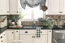 a chic farmhouse kitchen done in black, grey and white, plaid textiles, black handles and a jute rug
