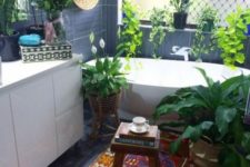 a colorful boho rug and lots of potted plants plus a basket on the wall make the bathroom free-spirited
