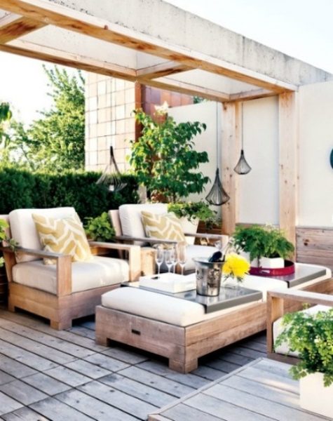 a contemporary rustic patio with wooden upholstered furniture, pendant candle lanterns, greenery and bright touches
