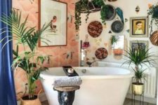 a crazy boho bathroom with a bright wallpaper wall, decorative baskets, potted plants, a gallery wall, boho rugs and textiles
