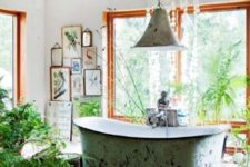 a gypsy bathroom with a mosaic tile floor, a gallery wall, potted plants, a pendant lamp, a shabby bathtub
