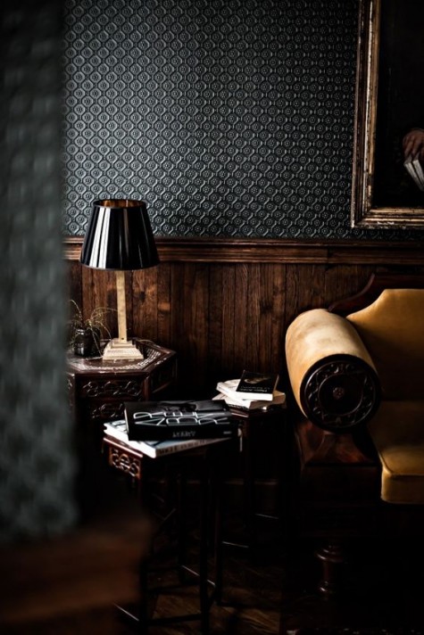 a moody masculine space done with dark textural wallpaper and dark-stained wainscoting for a refined touch