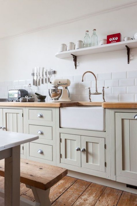 a neutral farmhouse kitchen with dove grey vintage cabinets, butcherblock countertops and benches plus a neutral table