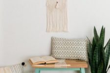 a small boho entryway with a tiny bench, a hack by IKEA, boho pillows, a macrame hanging, a faux fur rug and a basket for storage
