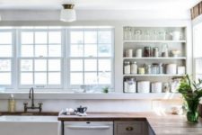 a vintage meets modern farmhouse kitchen with grey cabinets, butcherblock countertops, built-in shelves and a vitnage faucet