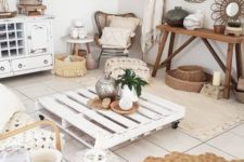 a whitewashed boho living room with shabby whitewashed furniture, jute and rattan items, baskets and candle lanterns