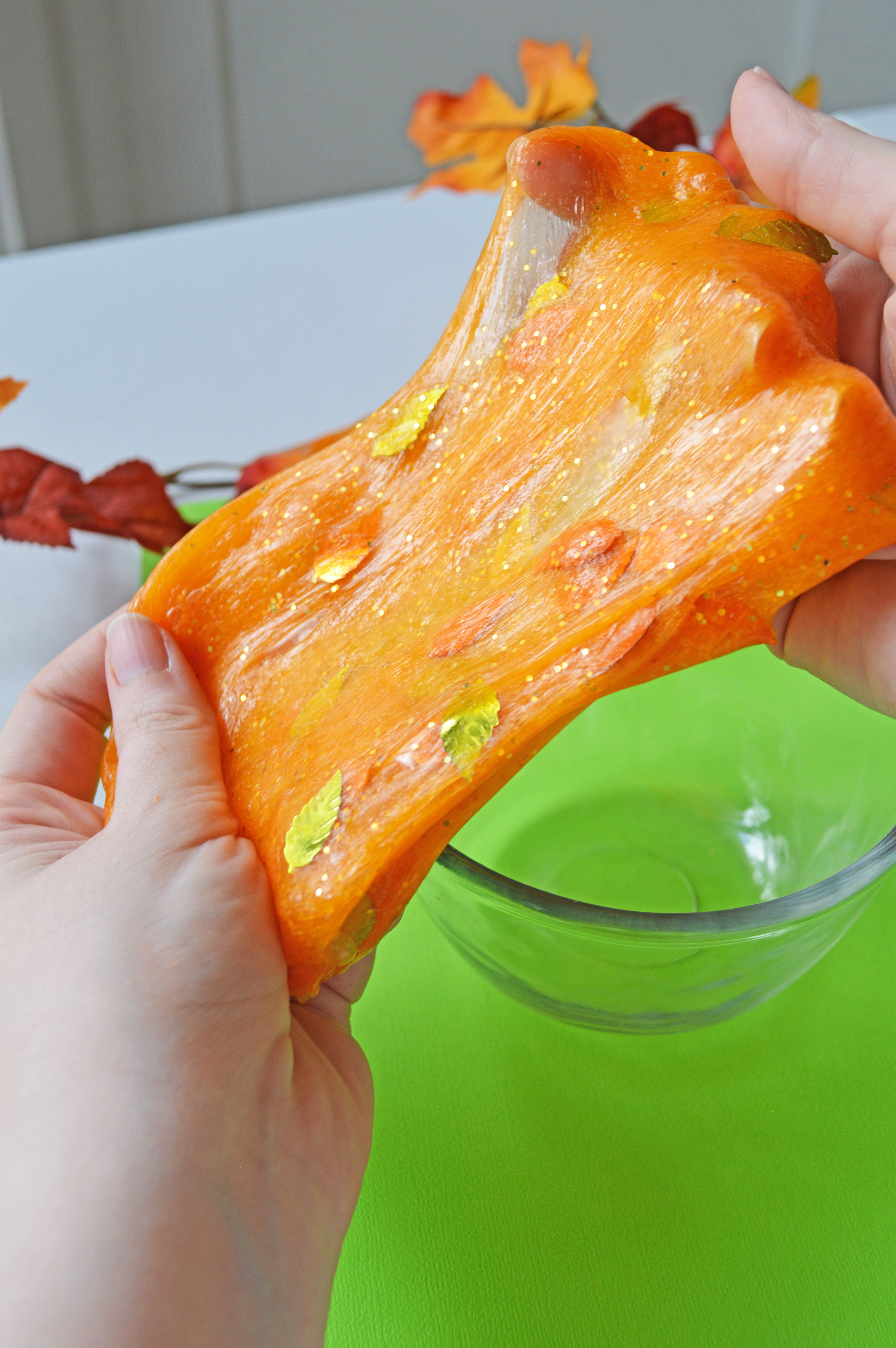 DIY bright orange slime with glitter and leaves
