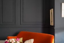 graphite grey wainscoting creates a moody ambience and a white floor and colorful furniture spruce it up