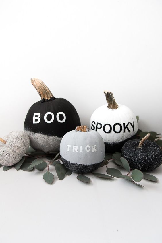 monochromatic pumpkins with stenciled letters, sparkles, greneery are great decorations for Halloween