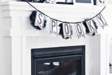12 a black and white mantel with a banner, wreaths, signs, blackbirds, artworks and candle lanterns is a timeless option