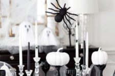 13 a black and white tablescape with black and sheer glasses, spiders, pumpkins and candles for Halloween