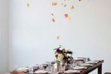 13 a gorgeous overhead fall leaf installation over the dining table is a very modern and bold idea
