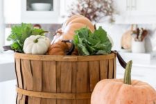 15 a wooden basket with fresh pumpkins and veggies is a cool and edible fall decoration