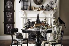 17 a fantastic black and white Halloween scene with signs, faux birds, skeletons, bottles, candles and a candle chandelier