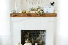 19 a modern pumpkin display on the mantel and next to the fireplace plus greenery and candles