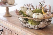 21 a wire basket with natural and velvet pumpkins and small flowers is ideal for a fall-infused space