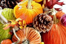 22 a bright fall arrangement of jewel tone velvet pumpkins, pinecones, fall leaves, blooms and acorns