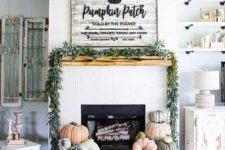 23 a fall fireplace display with lots of heirloom pumpkins, a greenery garland on the mantel and a sign