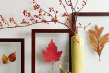 23 a gallery wall of bright fall leaves in frames and a berry arrangement in a vase for stylish fall decor with a modern feel