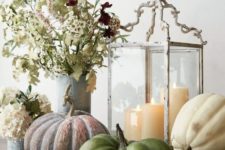 26 a catchy fall display with heirloom pumpkins, a vintage candle lantern, neutral blooms and greenery