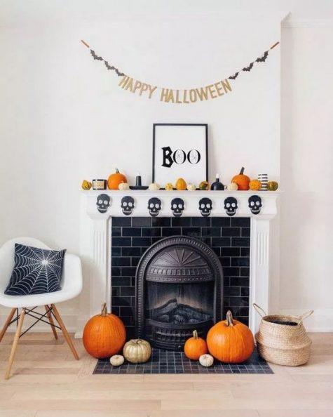 a laconic and stylish Halloween mantel with a skull bunting, natural pumpkins, candles and a Halloween bunting