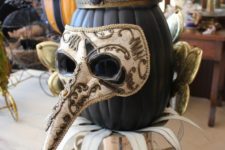 02 a cool matte black pumpkin in a crown and a mask is a gorgeous decoration or Halloween centerpiece