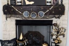 16 a glam black and gold mantel and fireplacewith a bunting, a sign, candles, pumpkins and black cheesecloth