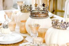 20 a gold and white glam Halloween tablescape with pumpkins in crowns, gold touches and gold placemats