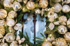 25 an evergreen wreath with gold and silver ornaments is a timeless idea for a front door