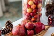 a cloche filled with small fresh apples almost to the top is a cool idea for fall decor and will do for Thanksgiving