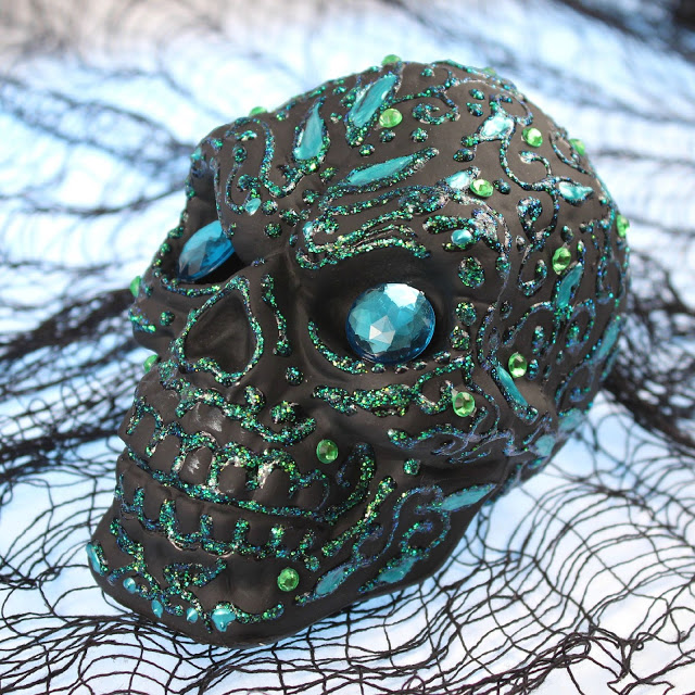DIY matte black Halloween skull with blue glitter patterns and rhinestones (via www.markmontano.com)