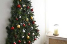 03 a wall-mounted Christmas tree with pine garlands and Christmas ornaments plus pinecones looks natural and cool