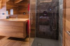 05 a contemporary attic bathroom with sleek wood and a shower space clad with black stone plus built-in lights