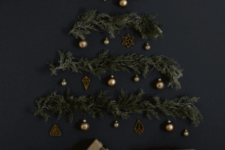 06 a Christmas tree on the wall made of evergreen branches, lights and dark metallic ornaments