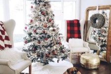 06 a farmhouse Christmas nook with a flocked tree with red and white ornaments, plaid blankets and white fur