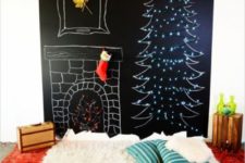 09 a chalkboard wall with a chalk tree decorated with lights, chalked fireplace and layered red and white rugs