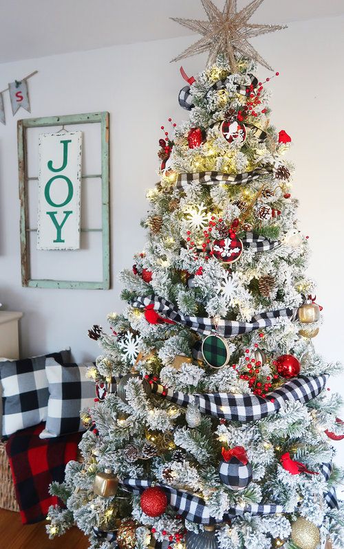 a flocked Christmas tree decorated with plaid ornaments and ribbons, lights, snowflakes and metallic touches