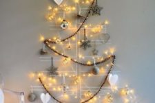 14 a drawn Christmas tree on the wall with lights, a garland and ornaments with lights inside is a modern idea