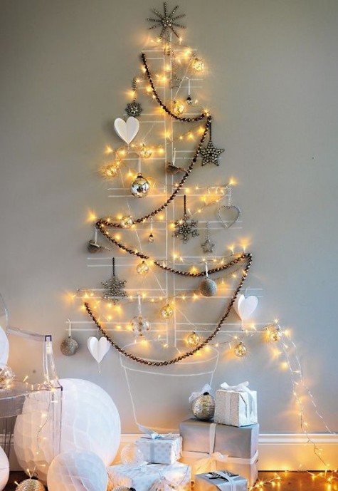 a drawn Christmas tree on the wall with lights, a garland and ornaments with lights inside is a modern idea