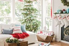 15 a cozy Christmas living room with evergreen wreaths and a Christmas tree, red ribbons, blankets and touches