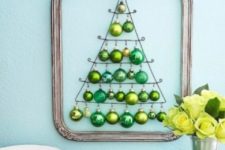 15 a framed wall-mounted Christmas tree of green ornaments of various shades looks very holiday-like