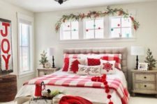 17 a cozy red and white Christmas bedroom with printed bedding, a knit blanket, a sign and some ornaments