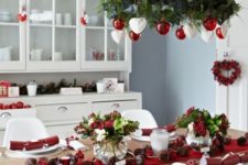 19 a red and white Christmas chandelier, a red table runner and berries for decorating a dining zone in a festive way